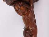 une sculpture ancienne en bois représentant un enfant tenant un bol sur la tête
