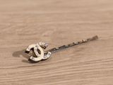 a picture of a hair pin on a wooden table