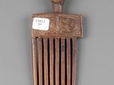 an old wooden comb with a man ' s head on it