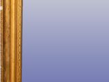 an antique gold framed mirror with a blue background