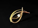 a close up of a gold ring with a pearl in it