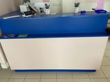 un comptoir d'accueil bleu et blanc dans une petite pièce