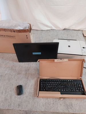 deux ordinateurs portables et un clavier dans une boîte posée par terre
