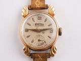 une montre-bracelet en or avec un bracelet en cuir marron