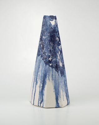 un vase bleu et blanc posé sur une surface blanche
