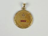 gros plan d'une médaille d'or sur une surface blanche