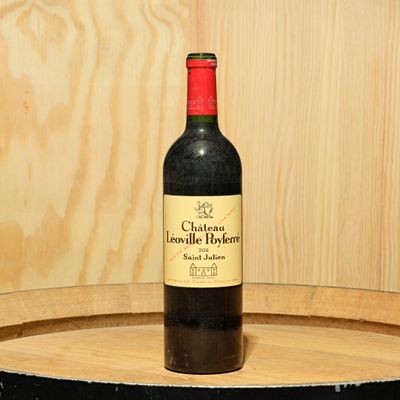 a bottle of wine sitting on top of a barrel