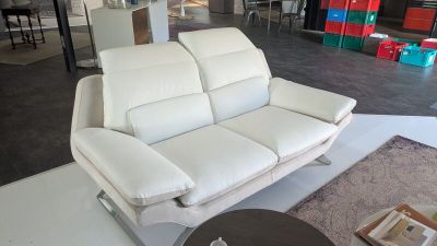 un canapé en cuir blanc dans un salon avec une table basse