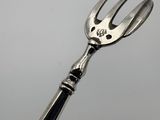 a fork with a face on it sitting on top of a pair of scissors