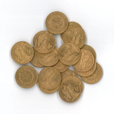 quelques pièces d'or empilées les unes sur les autres sur une surface blanche