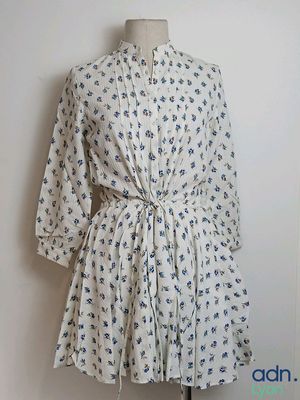 a dress on a mannequin stand on a white wall