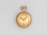une vieille montre de poche en or avec une chaîne, posée sur une surface blanche