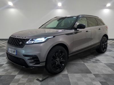 a grey land rover parked in a garage with a checkered floor