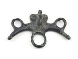 un objet métallique orné d'une croix, posé sur une surface blanche