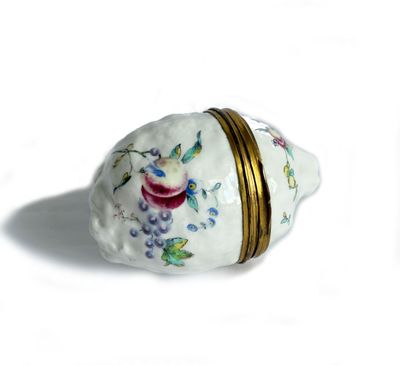 a small white shell with a gold band around it