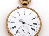 une montre de poche en or avec des chiffres romains sur le cadran