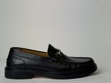 un gros plan d'une paire de mocassins noirs sur fond blanc