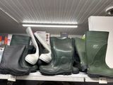 several pairs of rubber boots are on a shelf in a store