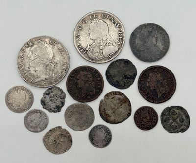 plusieurs types de pièces de monnaie sont présentés sur une surface blanche