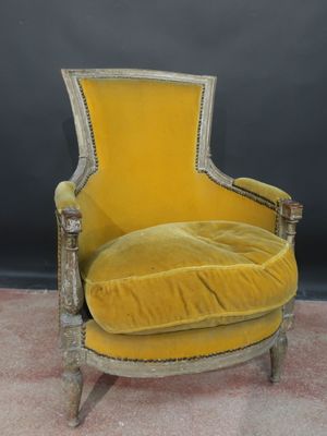 a yellow chair sitting on top of a carpeted floor next to a black wall