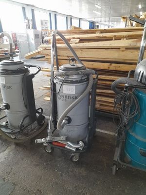 two vacuums that are sitting next to a pile of wood