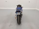 a blue motorcycle parked in a room with a white wall