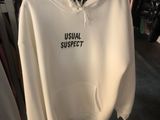 Le sweat à capuche blanc est suspendu à un portant dans un magasin de vêtements.