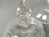 two clear wine glasses sitting next to each other on a table