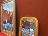 trois miroirs posés sur une étagère rouge dans une pièce