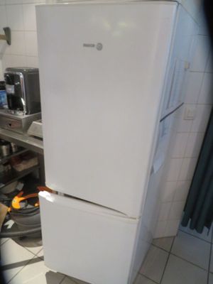 a white refrigerator sitting in a kitchen next to a stove
