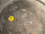 a silver plate with a yellow sticker on it