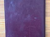 purple leather passport holder on a wooden table next to a pair of scissors