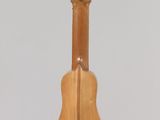 a wooden guitar hanging from a string on a wall