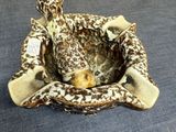 a giraffe that is sitting in a basket on the bed