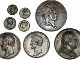 a close up of a group of silver coins on a white surface