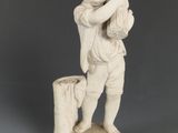 statue représentant un garçon tenant un panier de fruits sur une souche