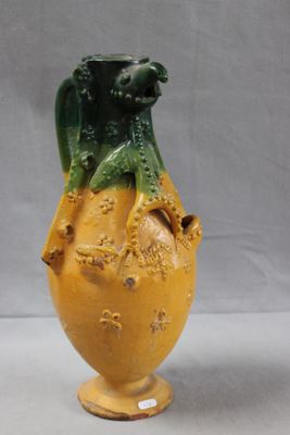 a yellow and green vase sitting on a table
