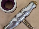 a silver bottle with a chain attached to it next to a roll of tape