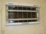 a white wall mounted heater on the wall next to a sign