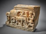 un ancien relief en pierre représentant un homme et une femme sur une charrette