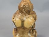 an image of a small figurine of a monkey sitting on its back