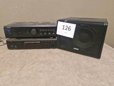 two speakers and a cd player on a table with a price tag