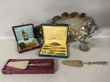 a lot of silverware on a table next to a silver tray