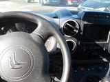 a steering wheel and dashboard of a car in a parking lot