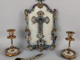 une image représentant un ensemble d'objets, notamment une croix, des bougeoirs et un miroir