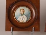 pair of miniature portraits of a boy and a girl in a wood frame