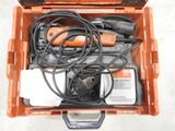 une boîte à outils orange posée par terre, contenant des outils