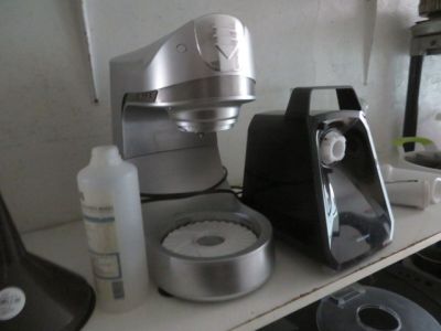 un mixeur argenté et noir posé sur une étagère à côté d'autres appareils électroménagers