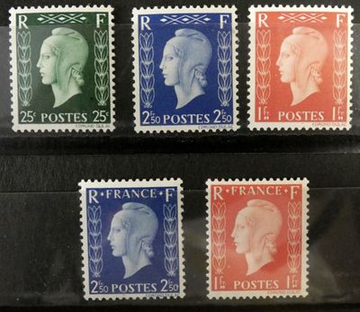 quatre timbres différents, de couleurs et de tailles variées, sur un fond noir