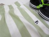 a pair of black and white shoes and a pair of green and white striped pants